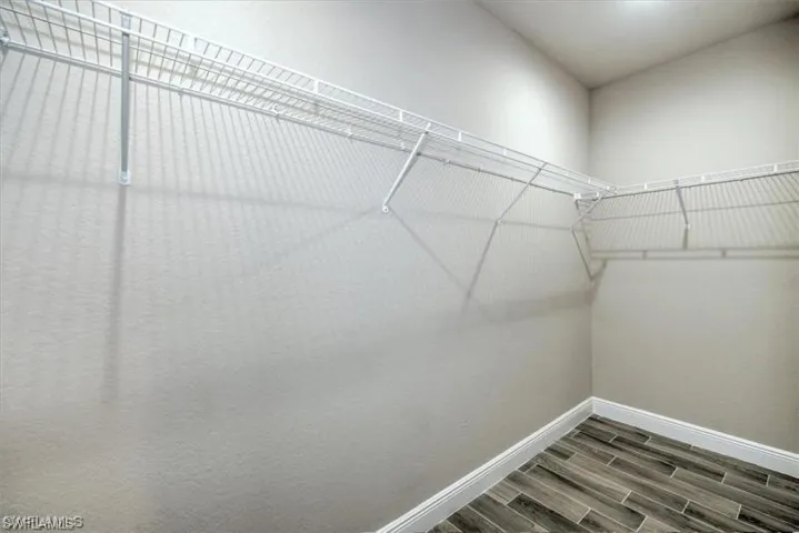Walk in closet with wood finish floors