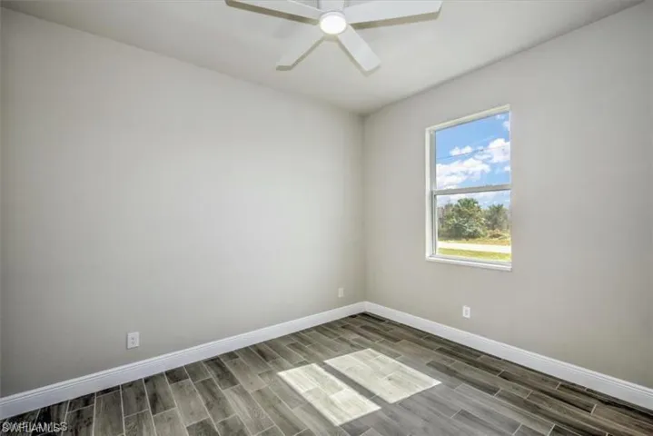 Unfurnished room with wood finish floors and ceiling fan