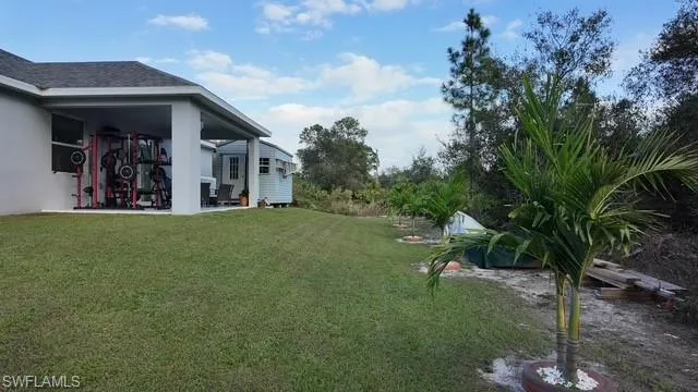 View of grassy yard featuring a patio