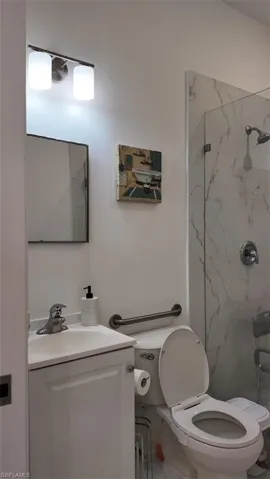 Bathroom with vanity and a marble finish shower