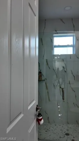 Full bathroom with a marble finish shower