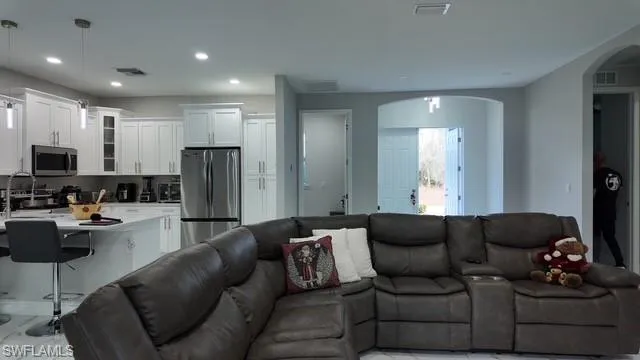 Living area with arched walkways and recessed lighting