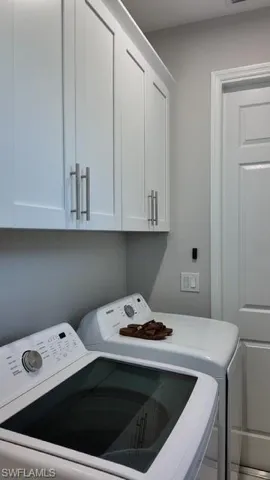 Laundry area featuring washing machine and dryer and cabinet space