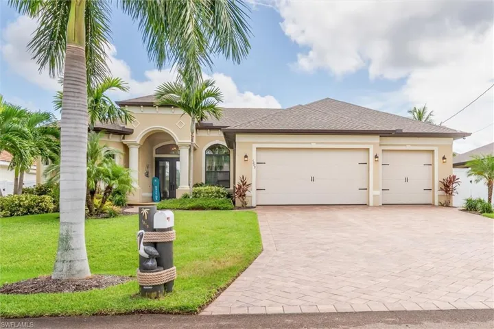 View of front of house with a garage and a front lawn