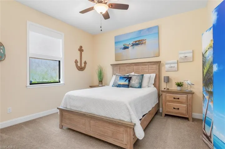 Carpeted bedroom featuring ceiling fan