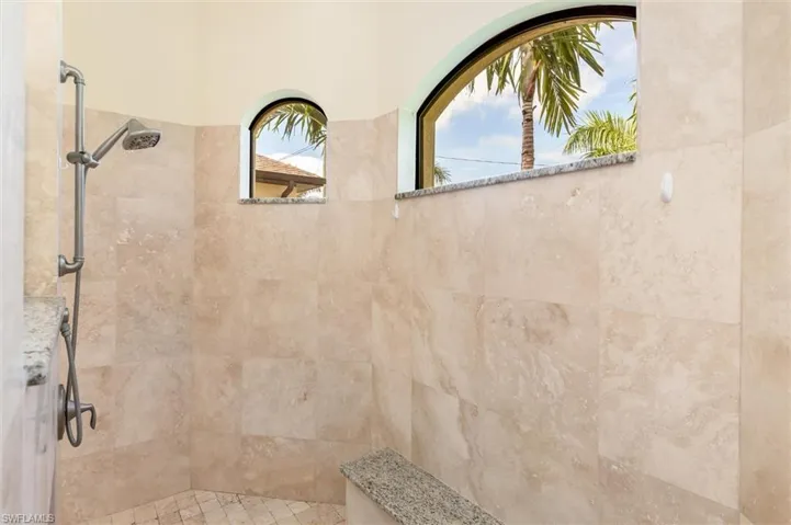 Bathroom with a tile shower and a healthy amount of sunlight