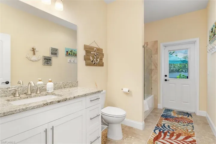 Full bathroom with vanity, toilet, tiled shower / bath combo, and tile patterned floors