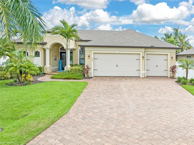 View of front of property with a front yard and a garage