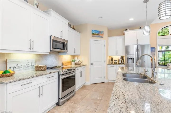 Kitchen with a healthy amount of sunlight, backsplash, stainless steel appliances, and sink