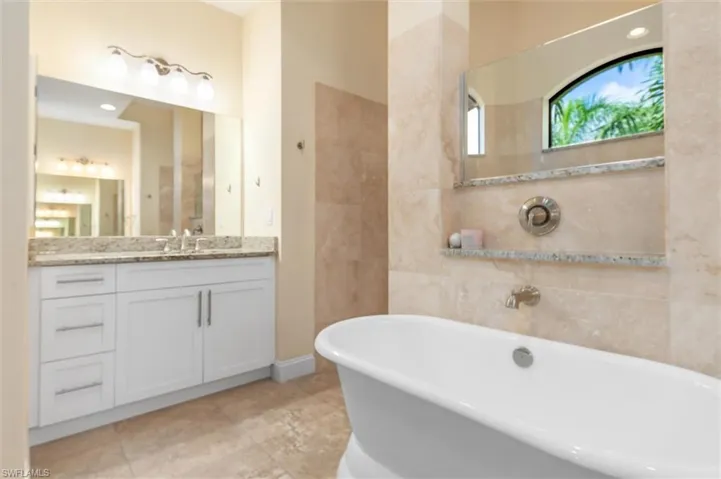 Bathroom featuring vanity, tile patterned flooring, and a bathtub