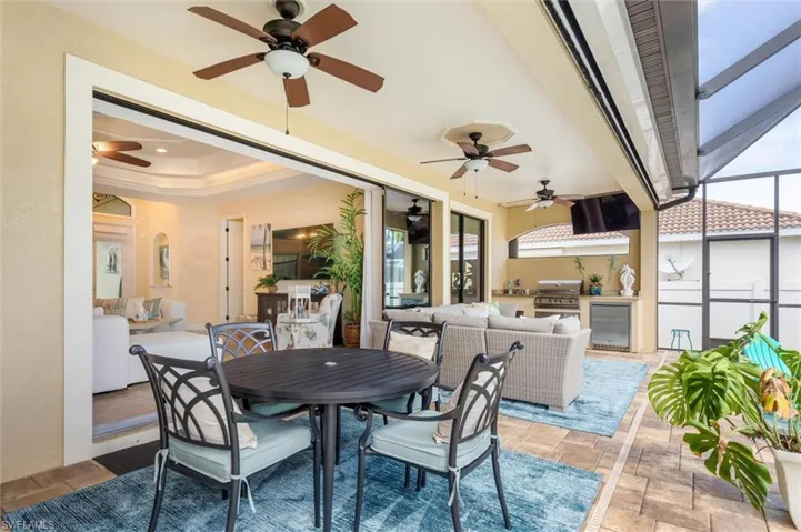 View of patio / terrace featuring grilling area, glass enclosure, area for grilling, and ceiling fan
