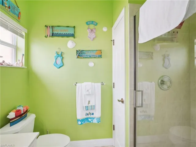 Bathroom with vanity, toilet, and a shower with door