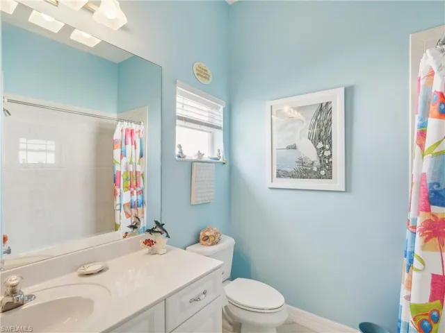 Bathroom with a shower with curtain, vanity, and toilet