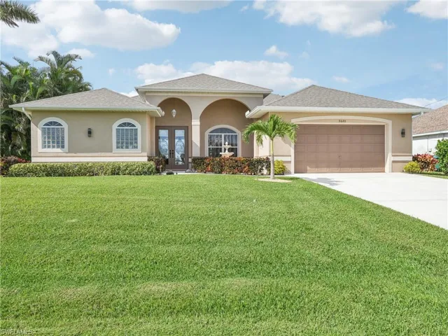 View of front facade featuring french doors, a front yard, and a garage
