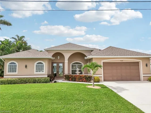 View of front of property featuring a front lawn, a garage, and french doors