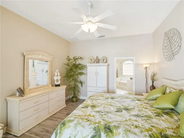 Bedroom with connected bathroom, ceiling fan, and wood-type flooring