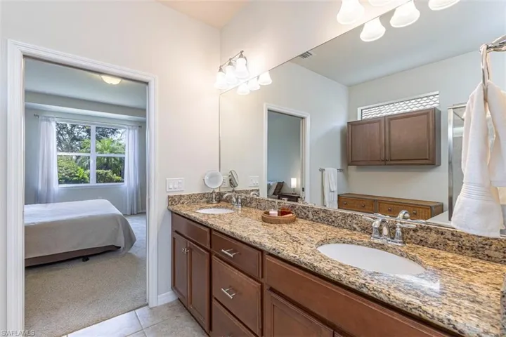 Ensuite bathroom with double vanity and light tile patterned floors