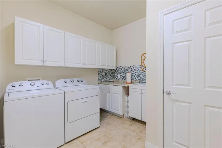 Laundry Room with cabinet space, Sink, washing machine and clothes dryer, and light tile patterned flooring