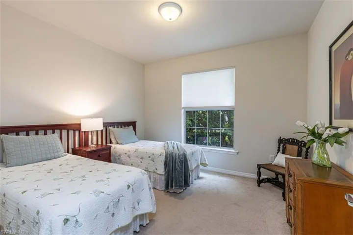 Bedroom with light carpet and baseboards