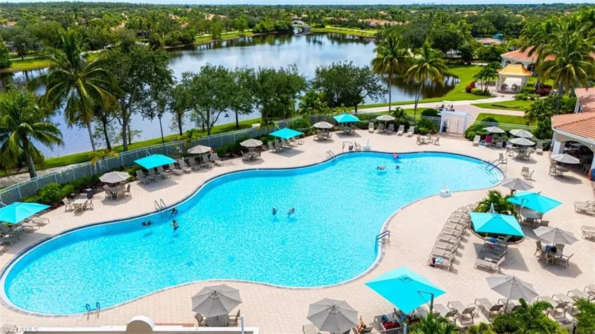 Community pool featuring a patio area, a water view, and outdoor dining space