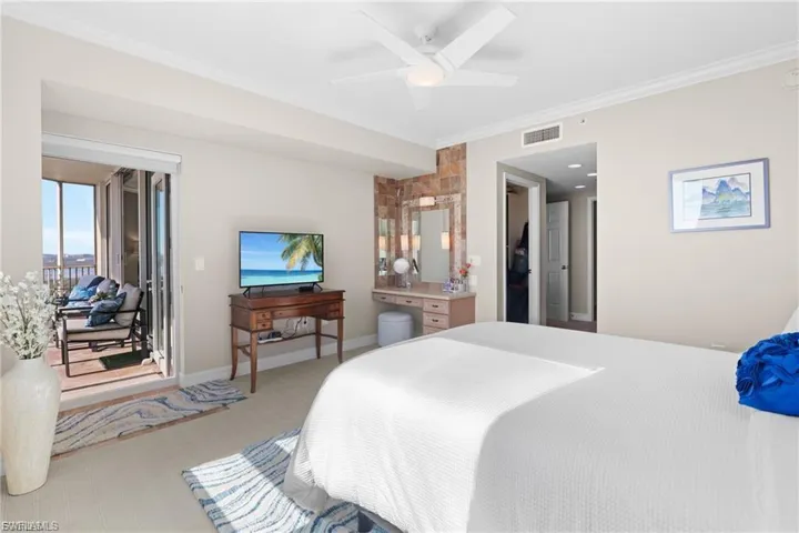 Carpeted bedroom featuring ornamental molding, access to exterior, and a ceiling fan
