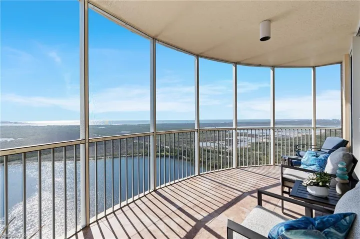 Sunroom with a water view and a wall of windows