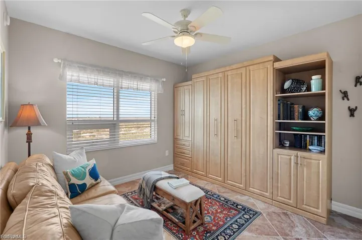 Living room with a ceiling fan and light tile patterned floors