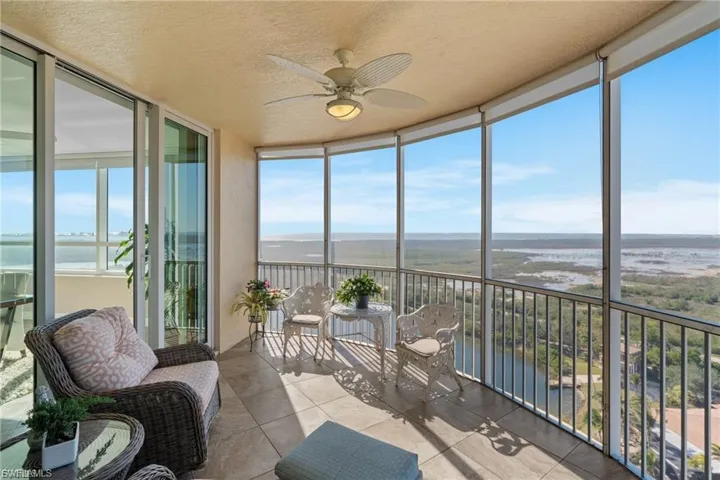 Sunroom featuring floor to ceiling windows, a water view, a textured ceiling, and tile patterned floors
