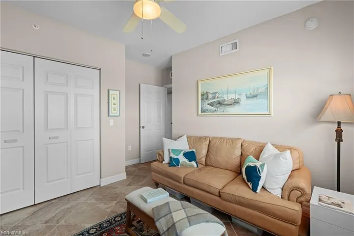 Living area with ceiling fan and baseboards