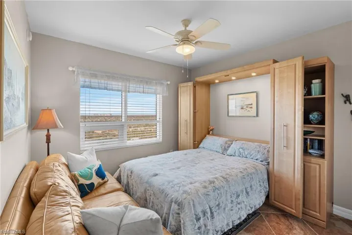 Tiled bedroom featuring ceiling fan
