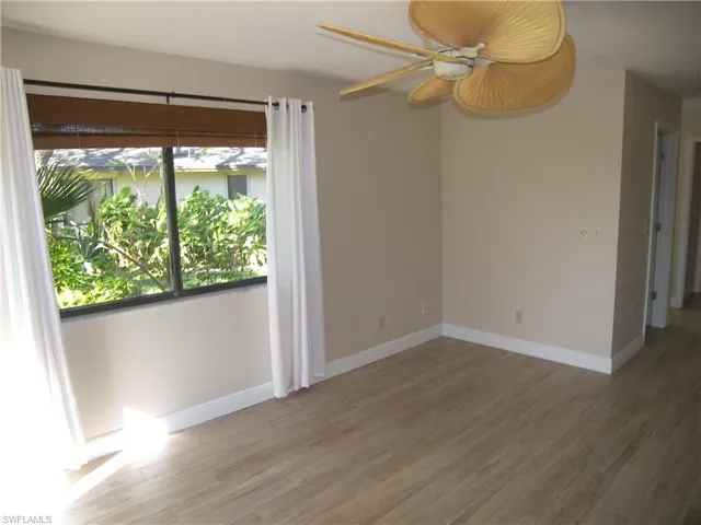 Spare room with ceiling fan and wood-type flooring