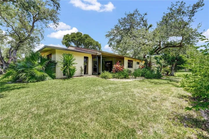 Back of property featuring stucco siding, a yard, and a patio area