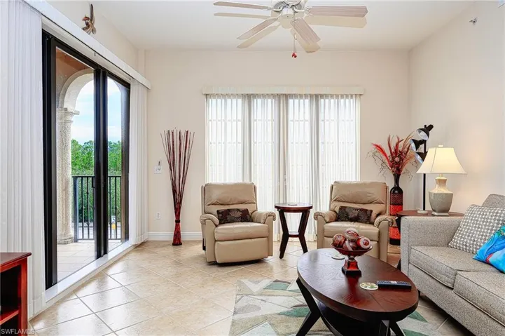 Living room with ceiling fan, light tile patterned flooring, and baseboards