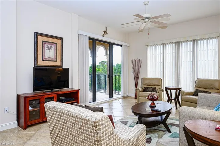 Living area with light tile patterned floors, ceiling fan, and baseboards