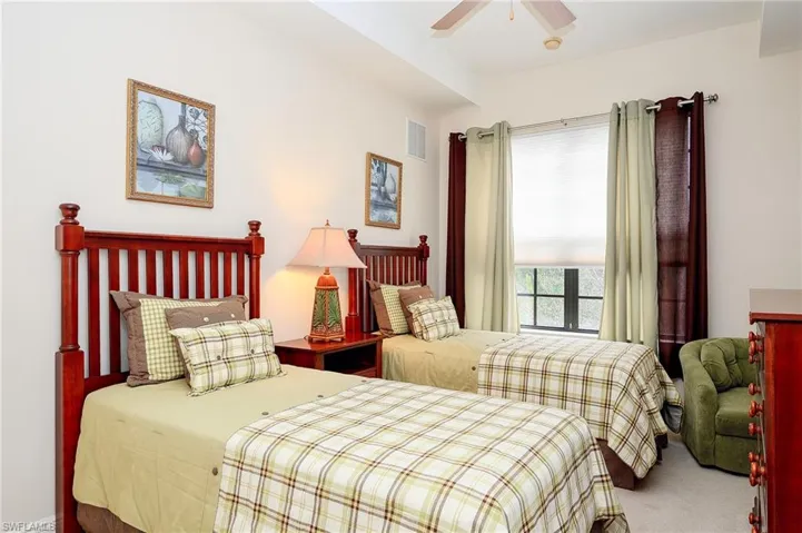Carpeted bedroom with ceiling fan and visible vents