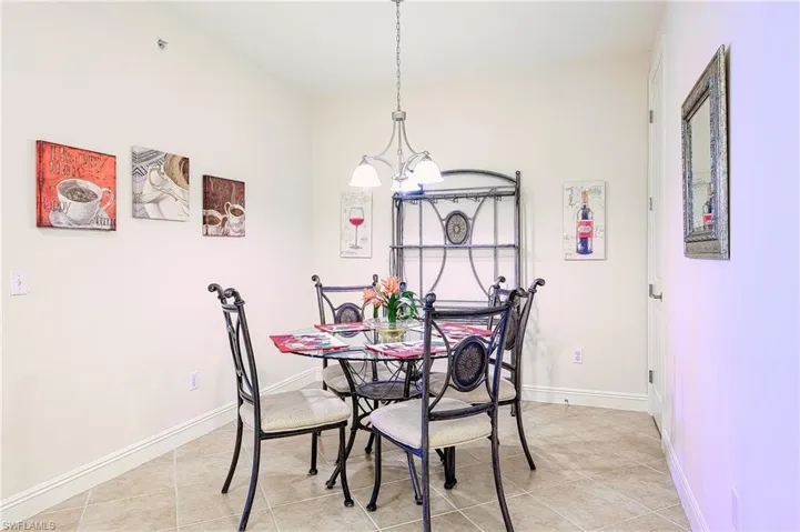 Dining room featuring a chandelier, light tile patterned flooring, and baseboards