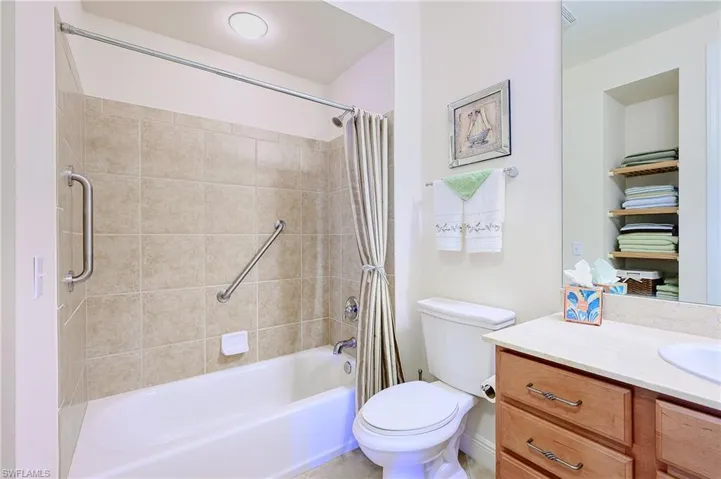 Bathroom featuring toilet, shower / bath combination with curtain, and vanity