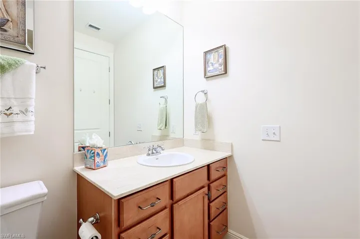 Half bathroom with toilet, visible vents, and vanity