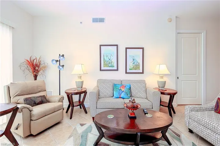 Living area with baseboards, visible vents, and light tile patterned flooring