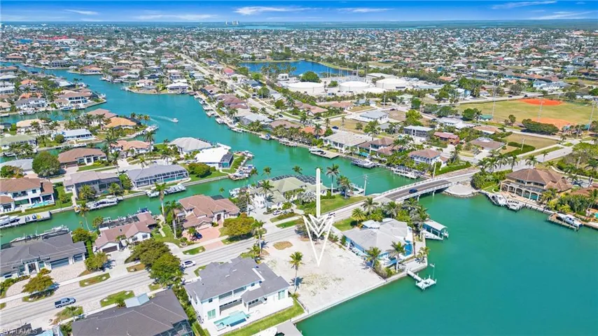 Aerial view of property's location with nearby suburban area and a nearby body of water