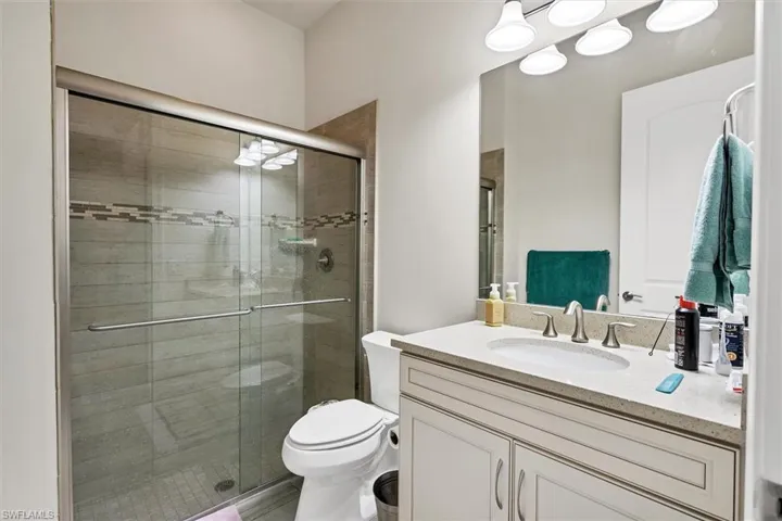 Bathroom with vanity, toilet, and walk in shower