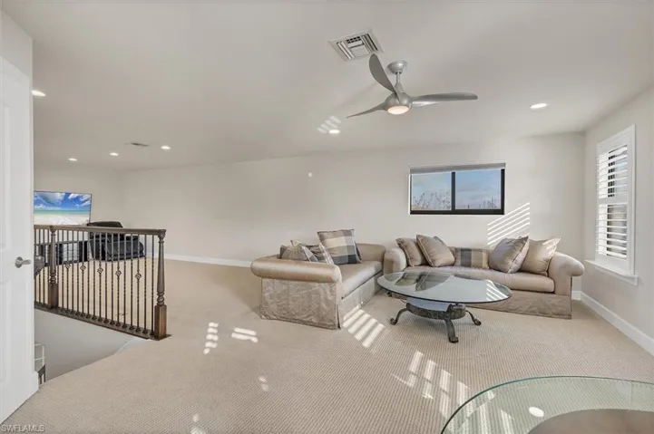 Living room with ceiling fan and light colored carpet