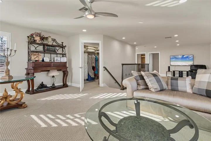 Carpeted living room with ceiling fan