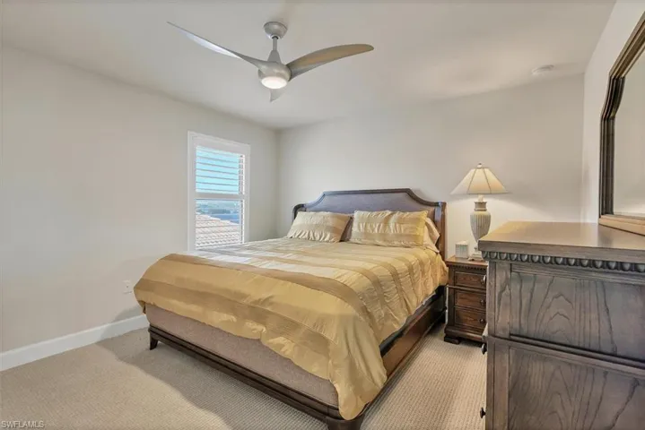 Bedroom featuring light carpet and ceiling fan