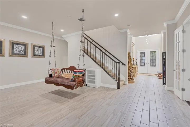 Foyer entrance with crown molding, french doors, and track lighting