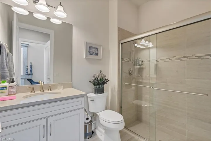 Bathroom with vanity, toilet, and walk in shower