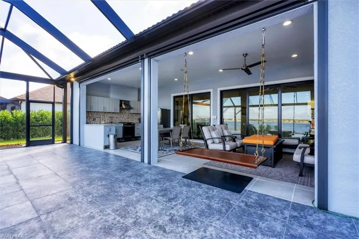 View of patio featuring ceiling fan and a lanai