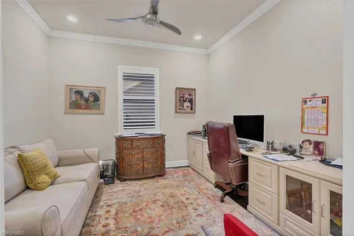 Office area with ceiling fan and ornamental molding