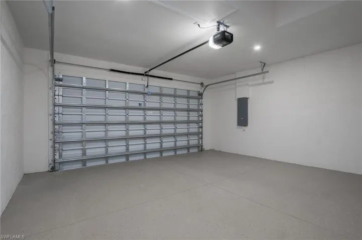 Garage featuring a garage door opener and electric panel