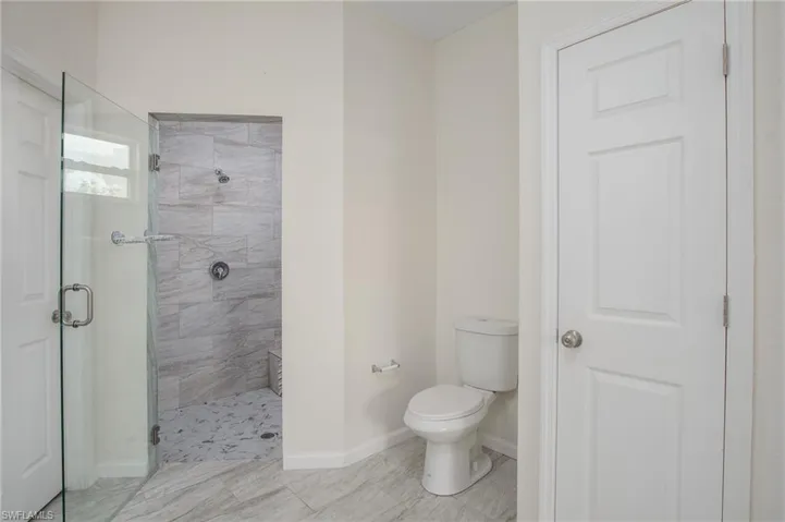 Bathroom with a spacious shower stall, toilet and linen closet